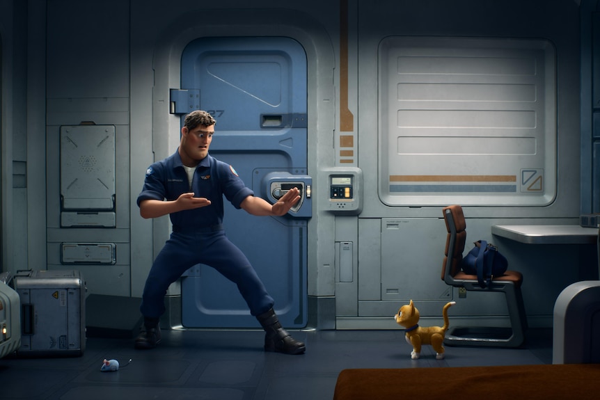 Animated white man with brown hair wears blue boiler suit and strikes a karate style position in front of small orange robot cat