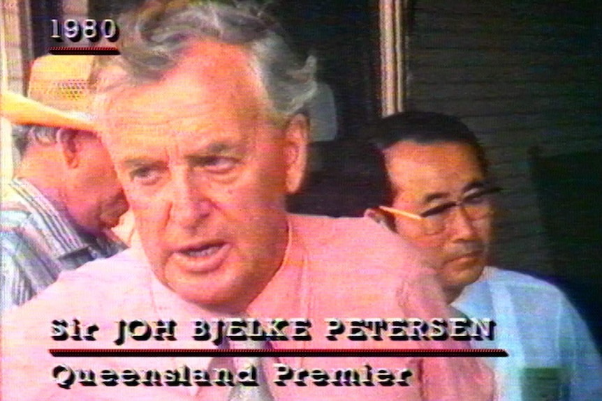 Sir Joh Bjelke-Petersen TV still 1980, mid-sentence serious expression, pin shirt, grainy image.