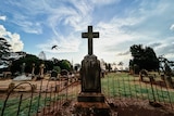 a bird flies past a grave in a cemetery