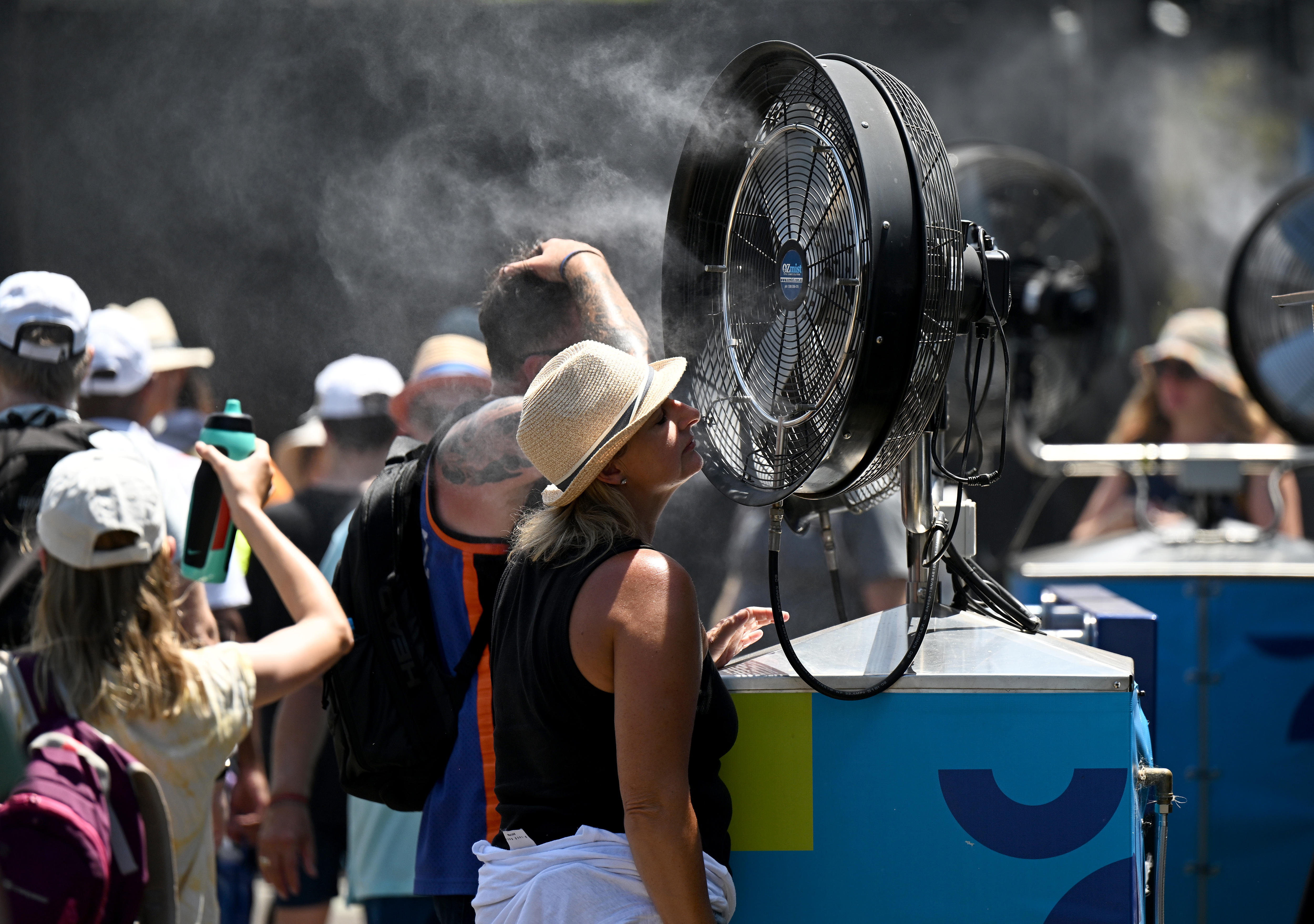 An Australian Open spectator cools themselves with a misting fan.