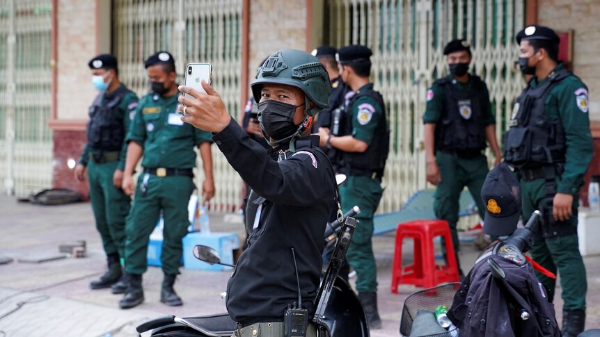 A policeman takes a photo with his phone