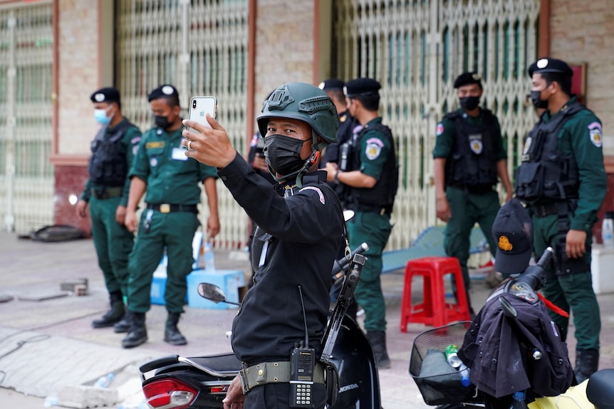 A policeman takes a photo with his phone