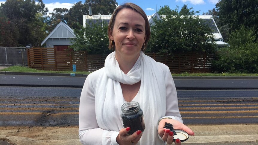 Nerida Mortlock, General Manager of Close the Loop Australia, holds a jar of the plastic and glass road surface additive.