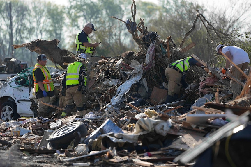 People search through a destroyed caravan.