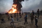 Children play next to a burning oil field in Qayarrah, south of Mosul, Iraq, Thursday Nov. 3, 2016.