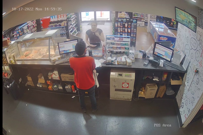Ein Screenshot von CCTV-Aufnahmen, die hinter dem Schalter einer Tankstelle aufgenommen wurden.  An der Theke steht eine blonde Frau. 