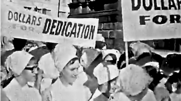 A black and white still from a 1966 video of Australian women protesting for equal pay.