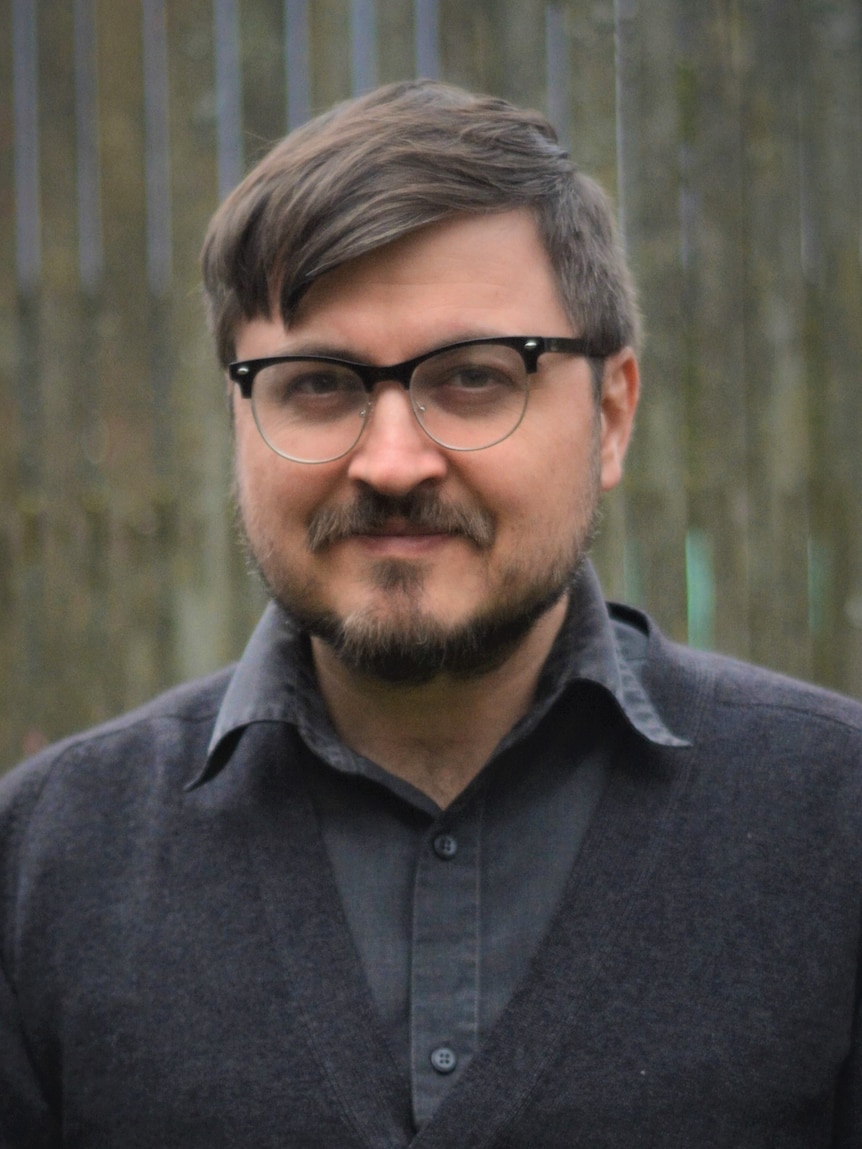 A smiling man wearing glasses.