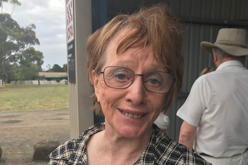 A woman in a checked shirt and glasses stands inside the Little River CFA shed.