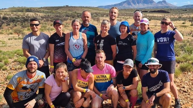 15 people huddled together wearing marathon running clothes
