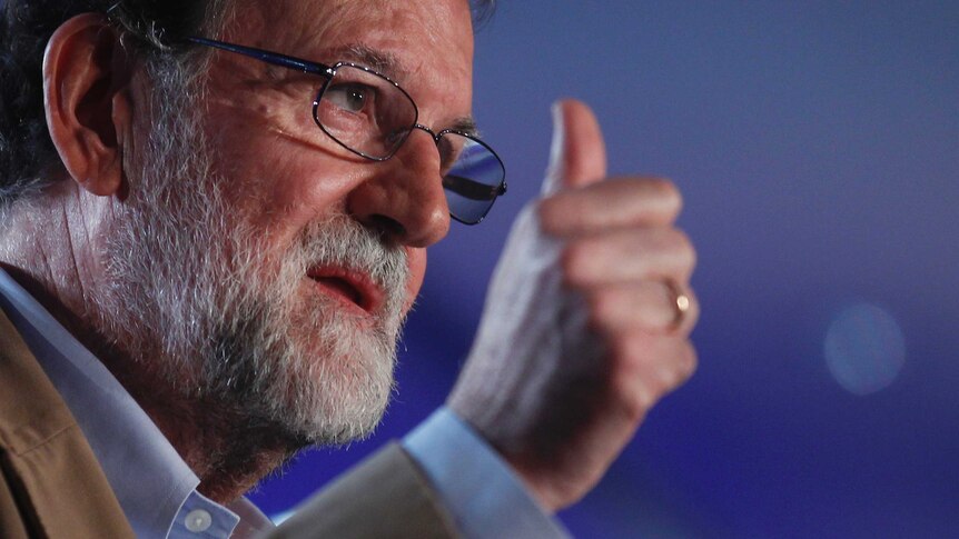 Spain's Prime Minister Mariano Rajoy holds his thumb up.