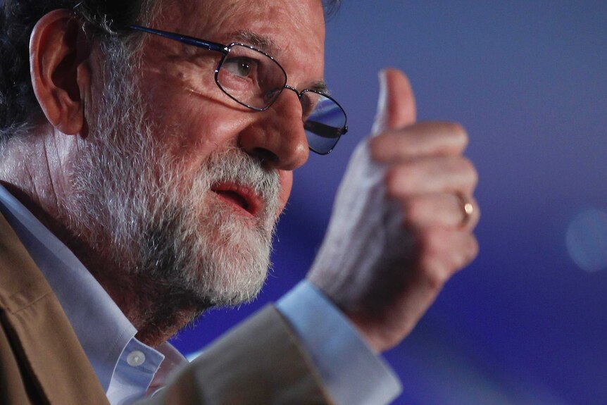 Spain's Prime Minister Mariano Rajoy holds his thumb up.