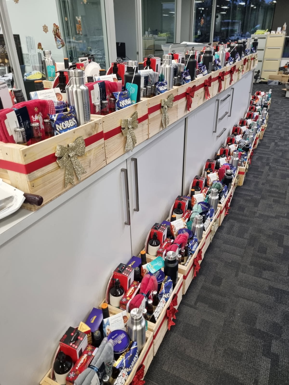 Boxes of hamper items line up a counter and floor.