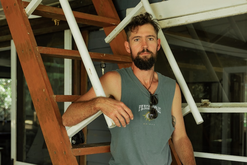 Joel sits on the ladder from his deck up to his flood refuge room in the roof