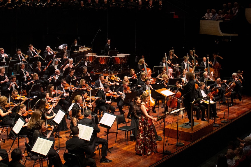 An orchestra, chorus and soprano soloist on stage during a performance.