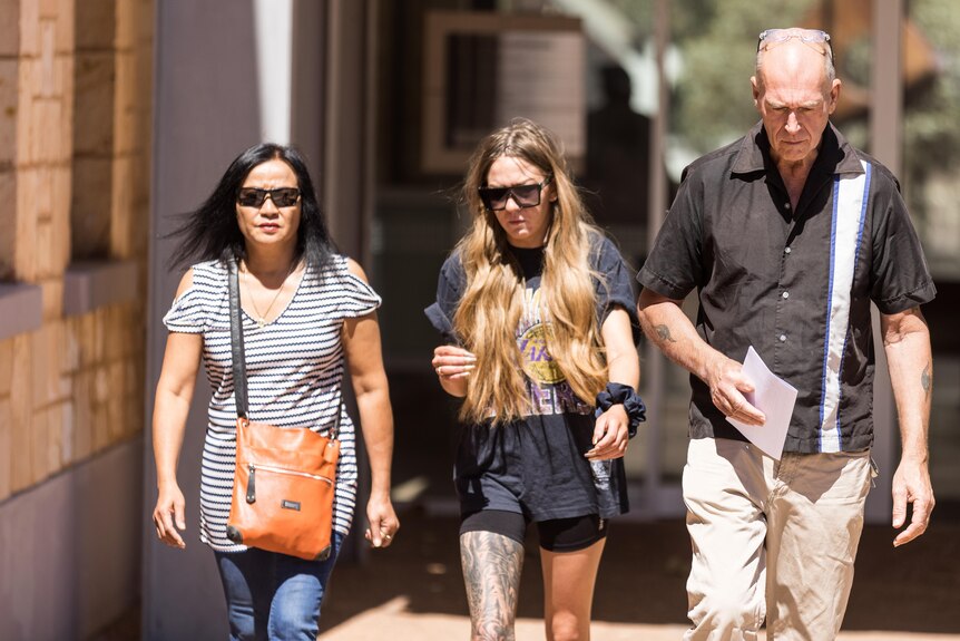 A man leaving court with two women.  