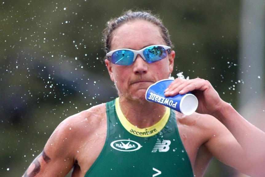 Emma Carney takes a drink as she competes in a triathlon in Melbourne in 2003.