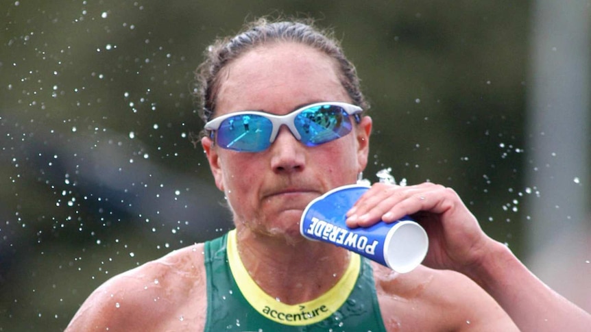Emma Carney takes a drink as she competes in a triathlon in Melbourne in 2003.