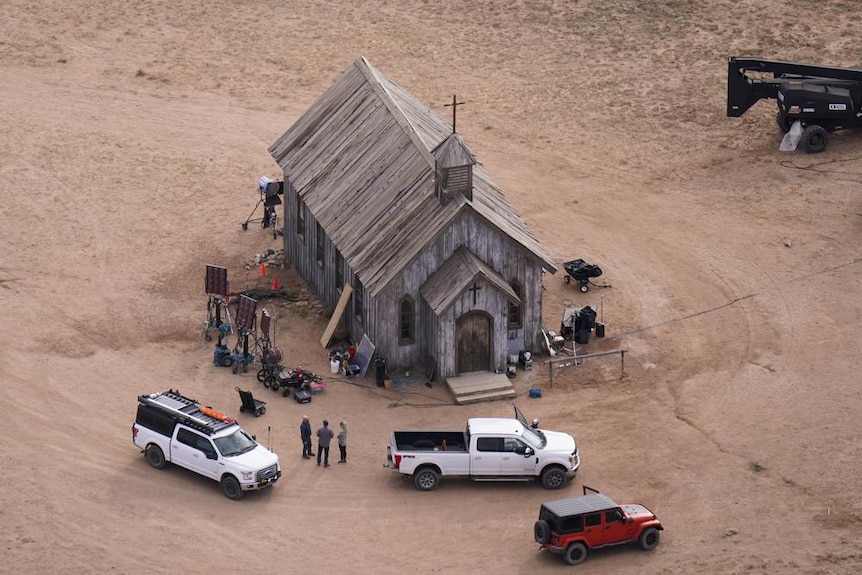 A police car blocks a road on a desert-themed movie set.