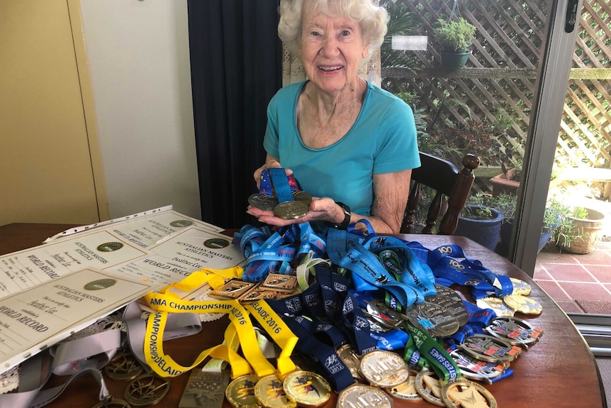 Heather Lee showing holding up her medals to camera.