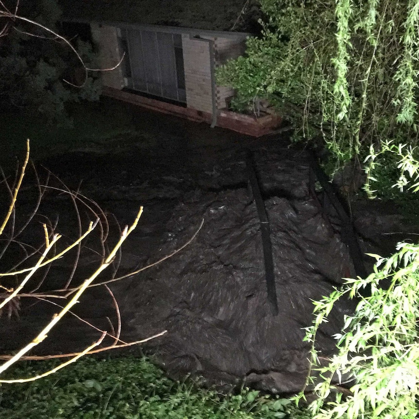 Floodwater rises around a home on Waterfall Gully Road.