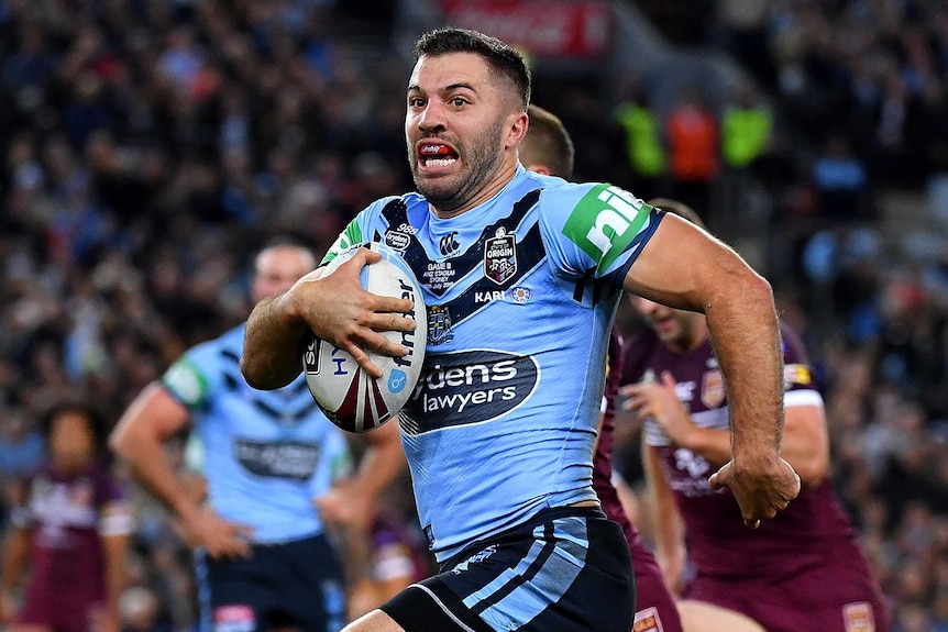 James Tedesco holds the ball and runs.