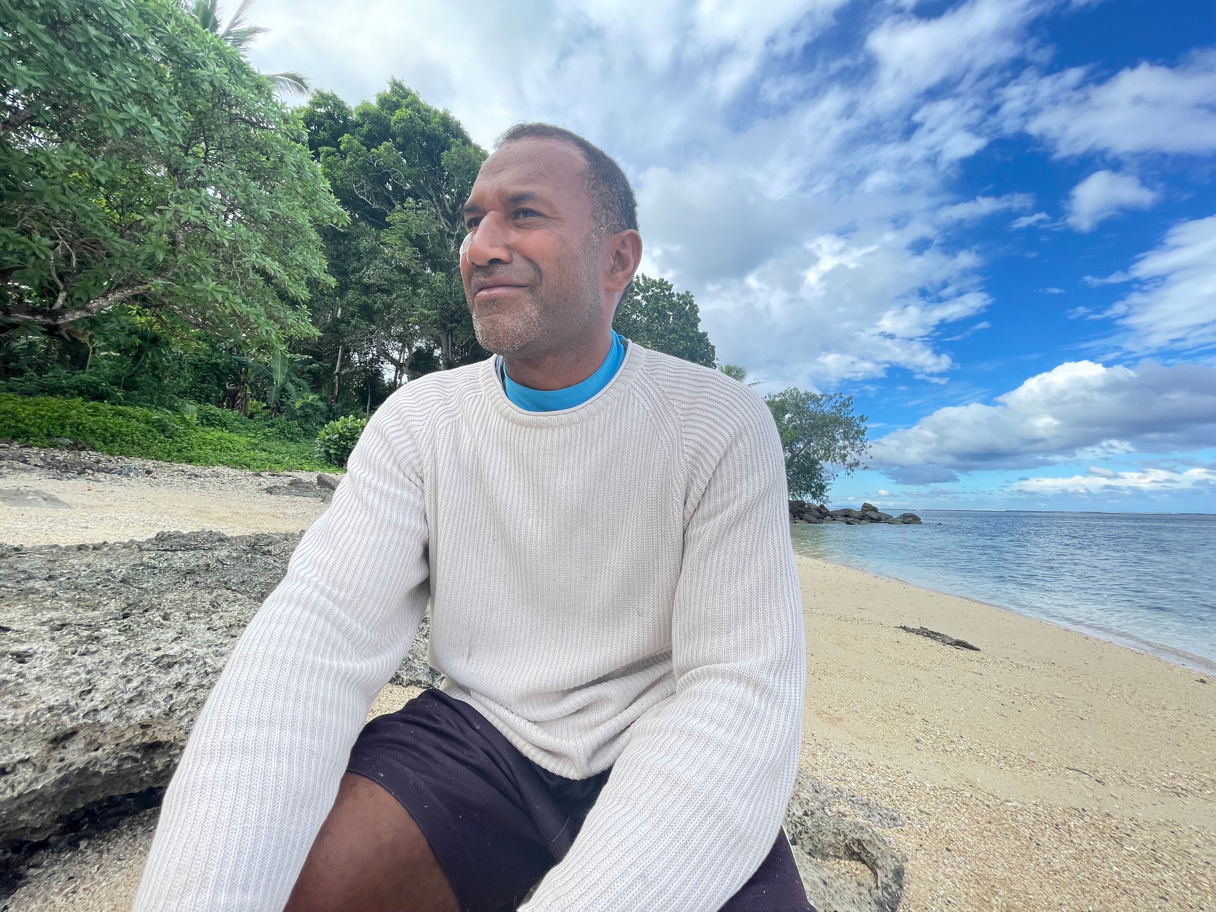 A Fijian man on the beac smiling 