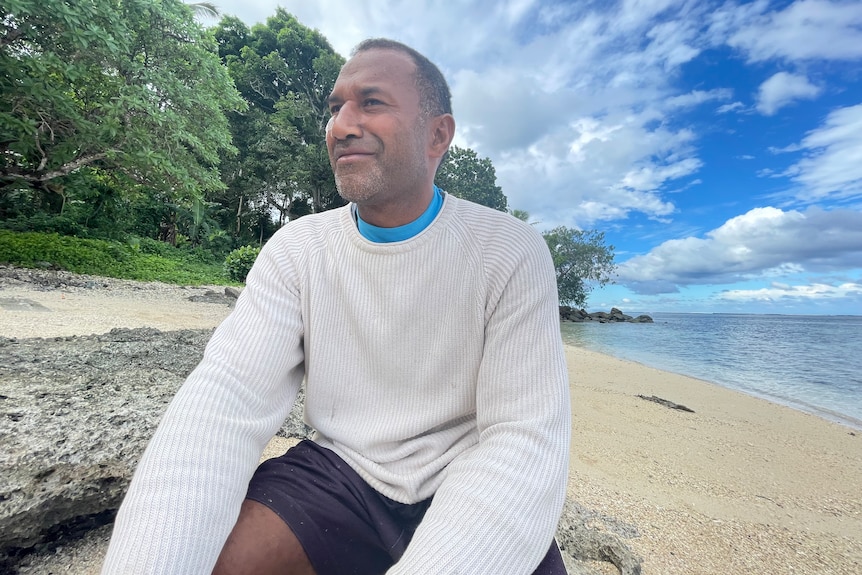 A Fijian man on the beac smiling 