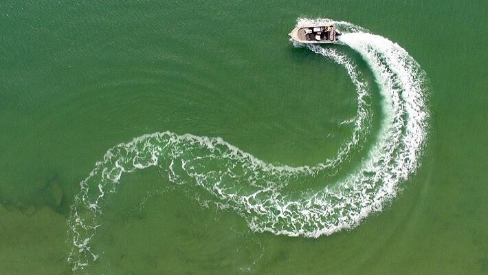 An aerial shot of a tinnie leaving an s-shaped wake in the Northern Territory