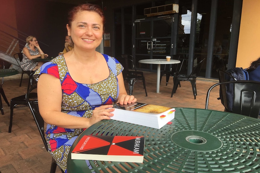 Sinem Ketenci sits at a cafe with a book