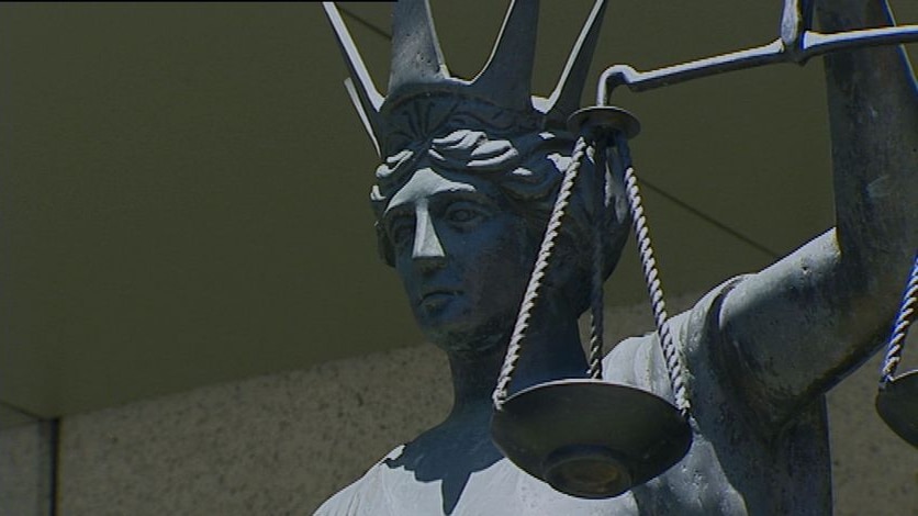 Close-up TV still of of Scales of Justice statue outside Brisbane CBD Law Courts complex