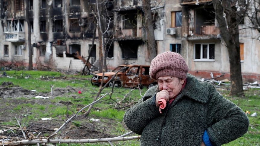 A woman cried out the front of a damaged building in Mariupol.