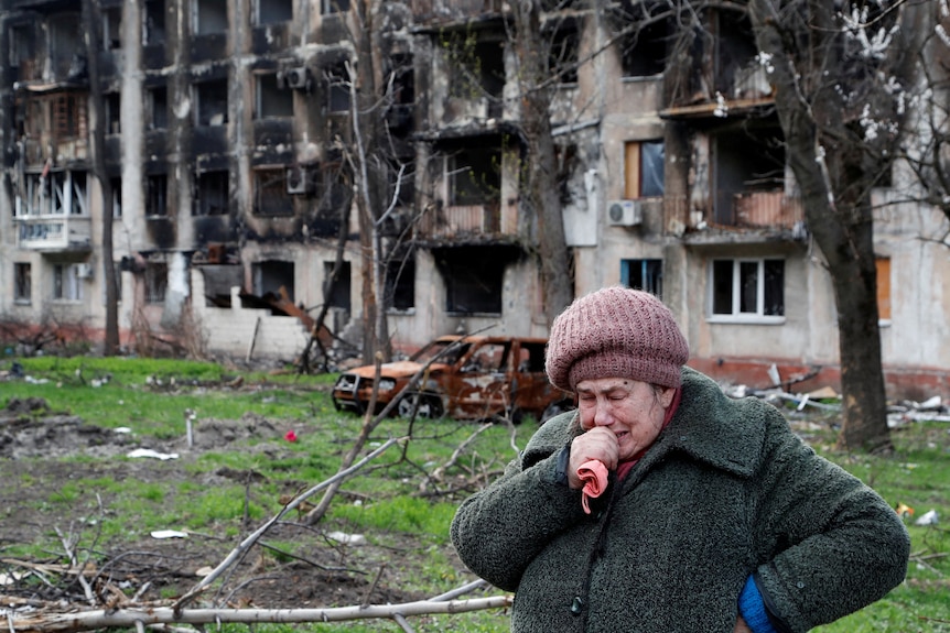 A woman cried out the front of a damaged building in Mariupol.