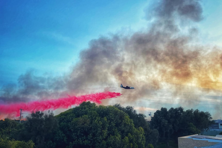 A plane drops fire retardant on a fire