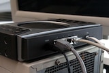 A broadband modem sits atop a computer