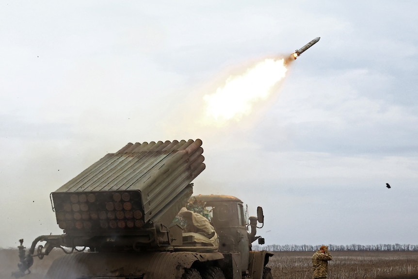 A rocket launch system rests on a frontline truck, as it fires a rocket into the sky.