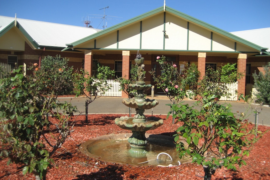 View through a rose garden to the driveway entrance to an aged care complex