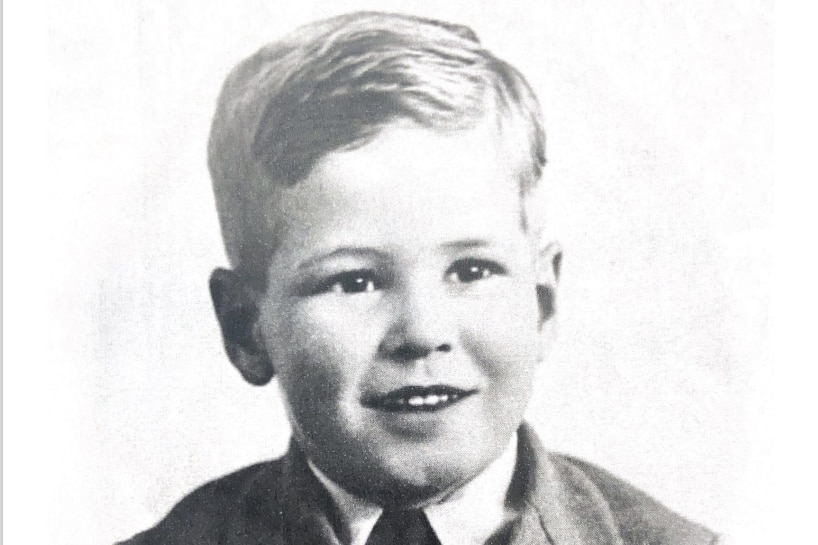 A black and white portrait of a small boy wearing a suit.