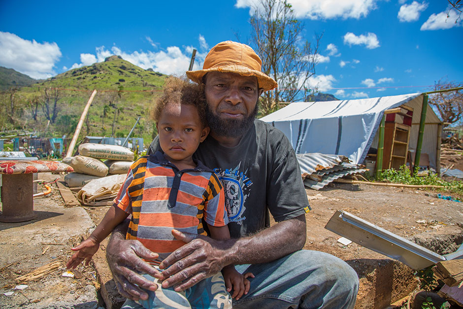 Man with his daughter in cyclone-damaged village