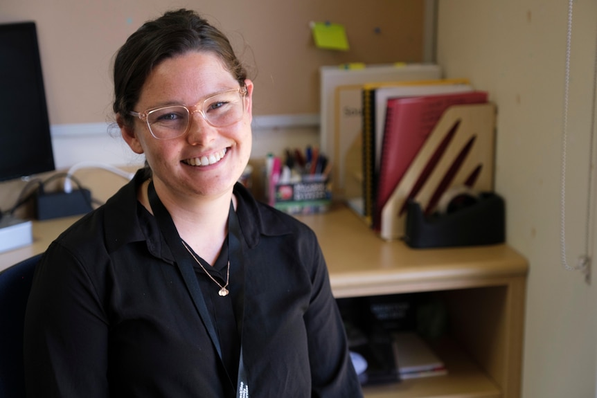 Young woman with glasses smiling at the camera 