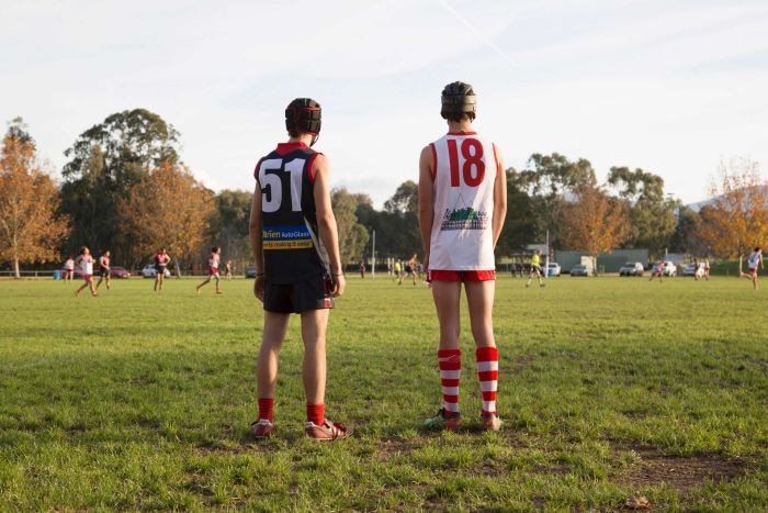 country footy players watch on