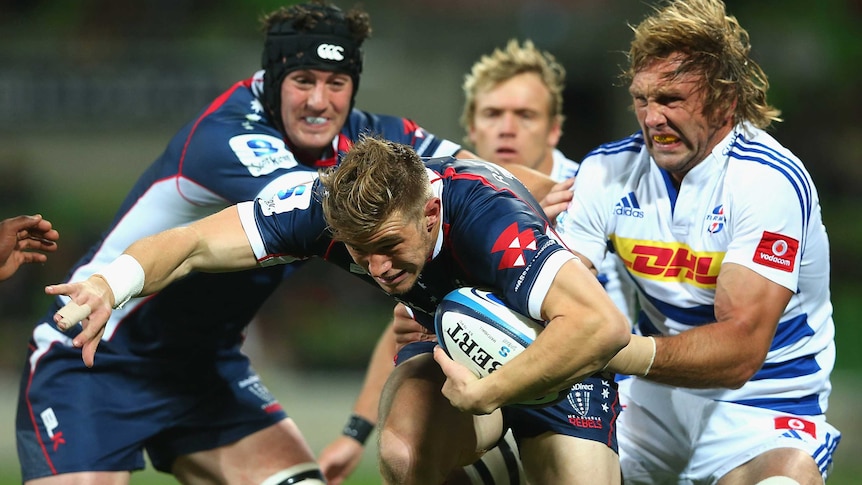 The Rebels' Jason Woodward is tackled by the Stormers' Andries Bekker at AAMI Park.