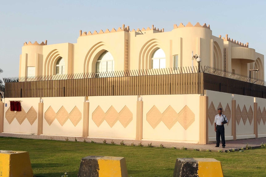 Security guards stand outside the Taliban political office in Doha.