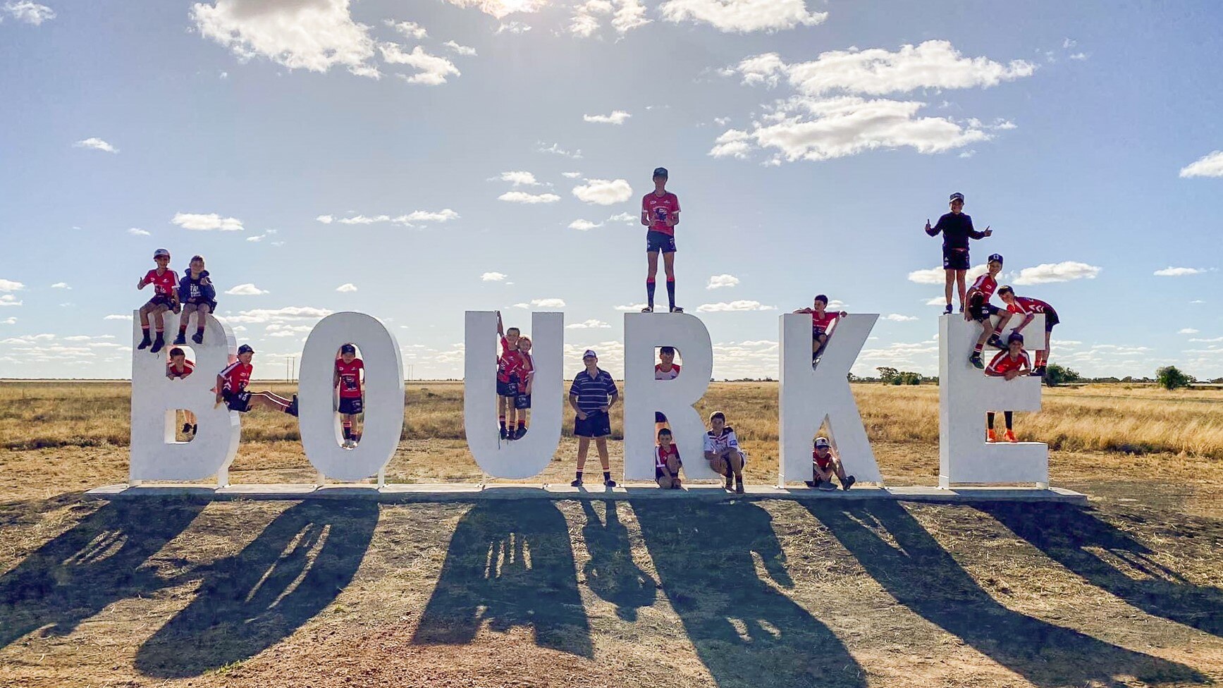 children standing on a hollywood style sign in bourke