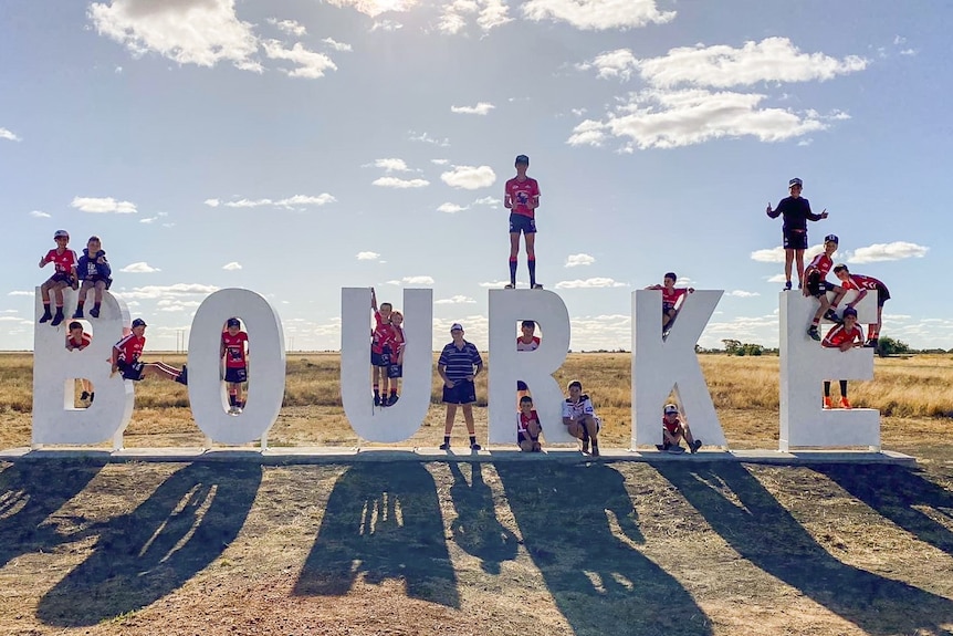 children standing on a hollywood style sign in bourke