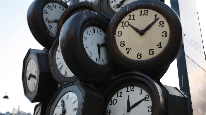 clocks piled on top of each other in a sculpture