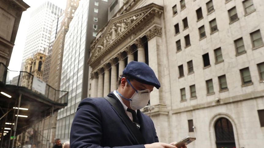 A man wears a protective mask as he walks along Wall Street during the coronavirus outbreak in New York City.
