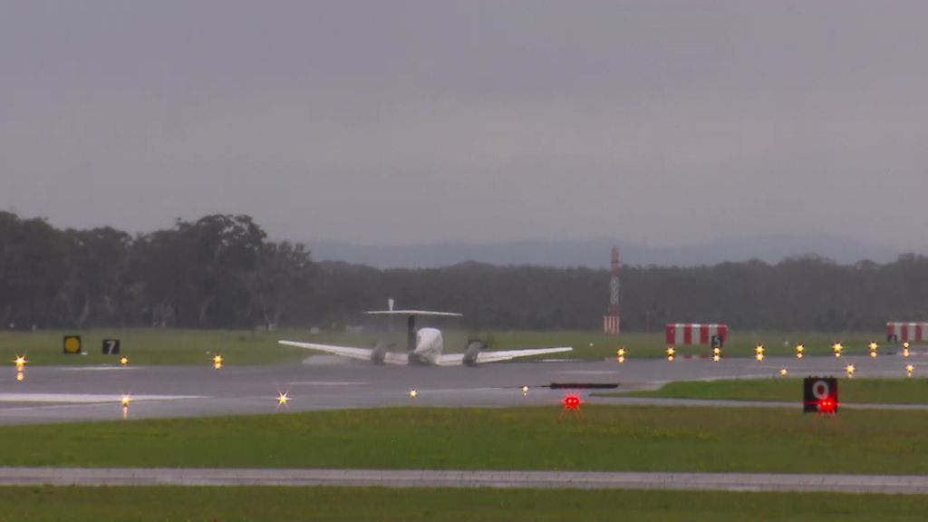 Light plane light on its belly on an airport runway.