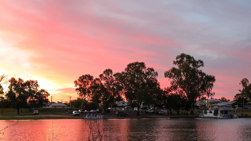 The Darling River in the foreground with a beautiful pink sunset over the small town of Wentworth.