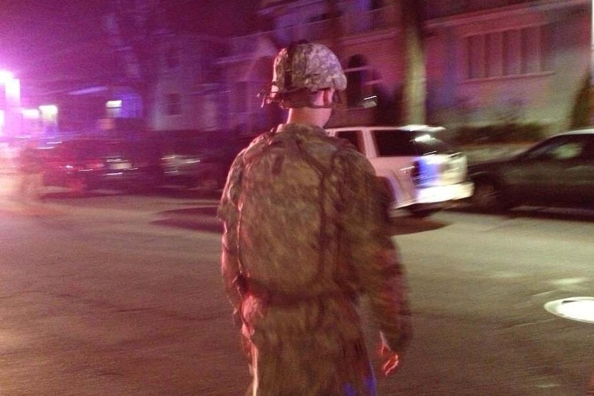 A soldier patrols the scene of a shooting incident in Watertown, near Boston